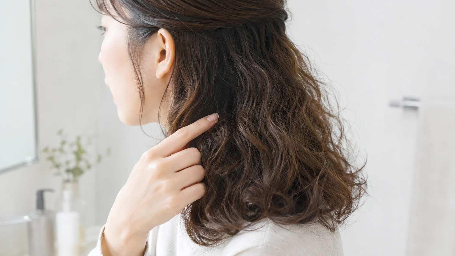 洗面所で、髪に手ぐしを通している様子