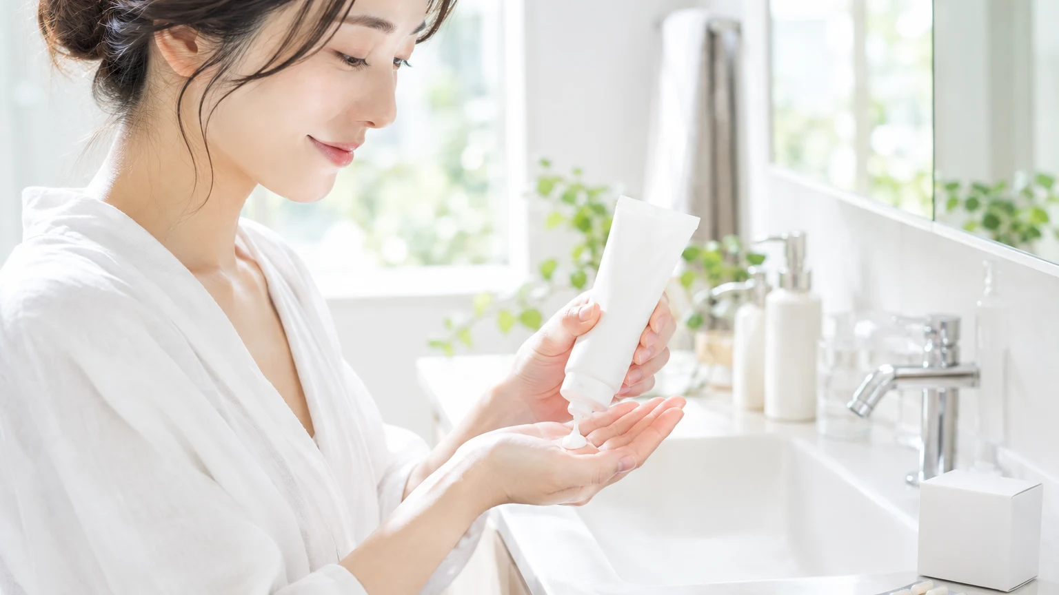 朝の洗面所で、日焼け止めを手のひらに出しているところ。そばにサプリの箱が置かれている