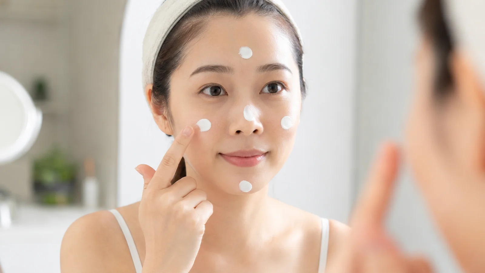 洗面所でヘアケア製品を手に取り髪の状態を確認する様子