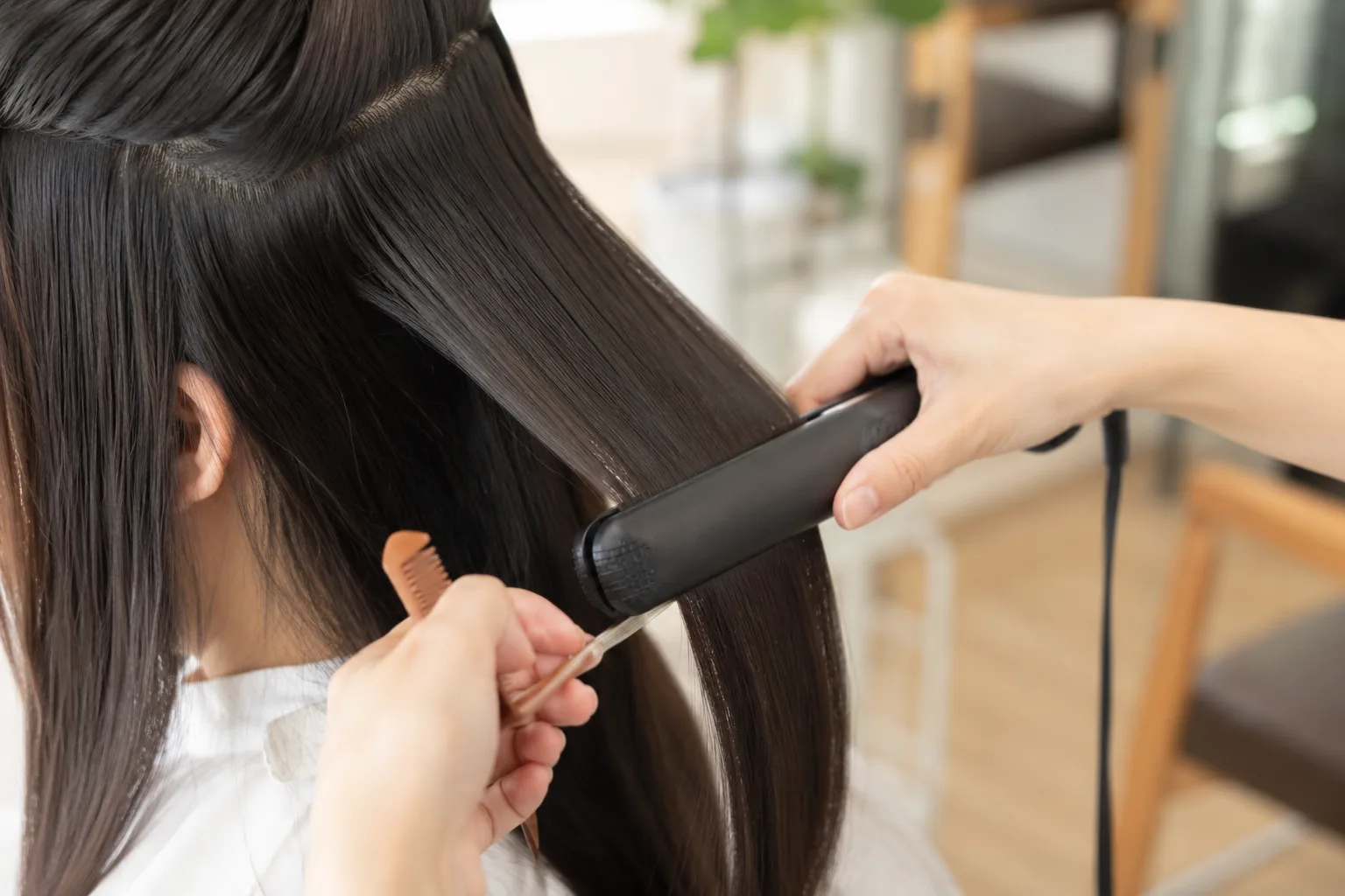 美容室でストレートアイロンによる集中ケアを受ける様子